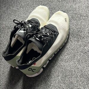 On Running Cream and Black Athletic Shoes